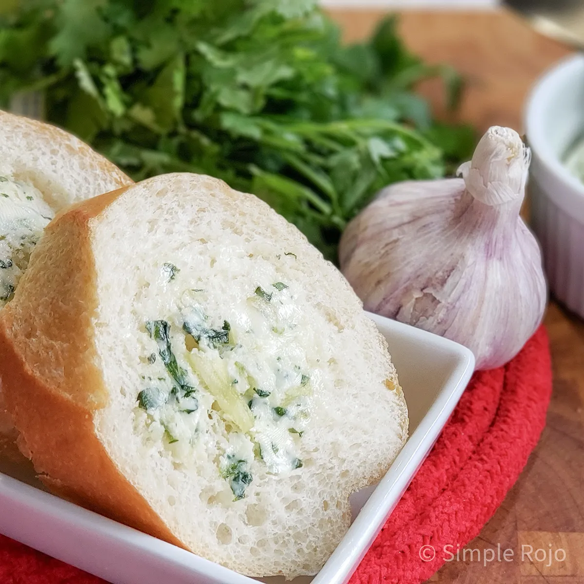 Panecillos con mantequilla de ajo y cilantro servidos en un plato.